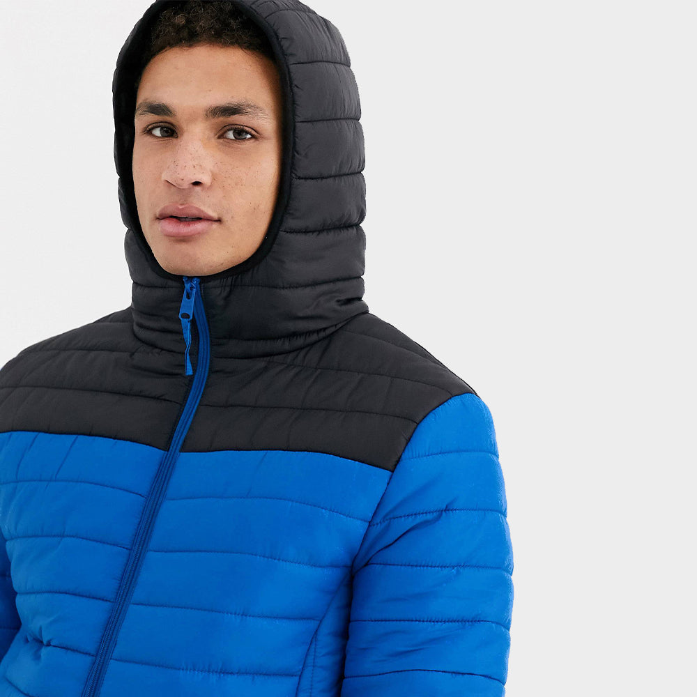 A man is showing wearing a blue quilted puffer jacket's hood for winters